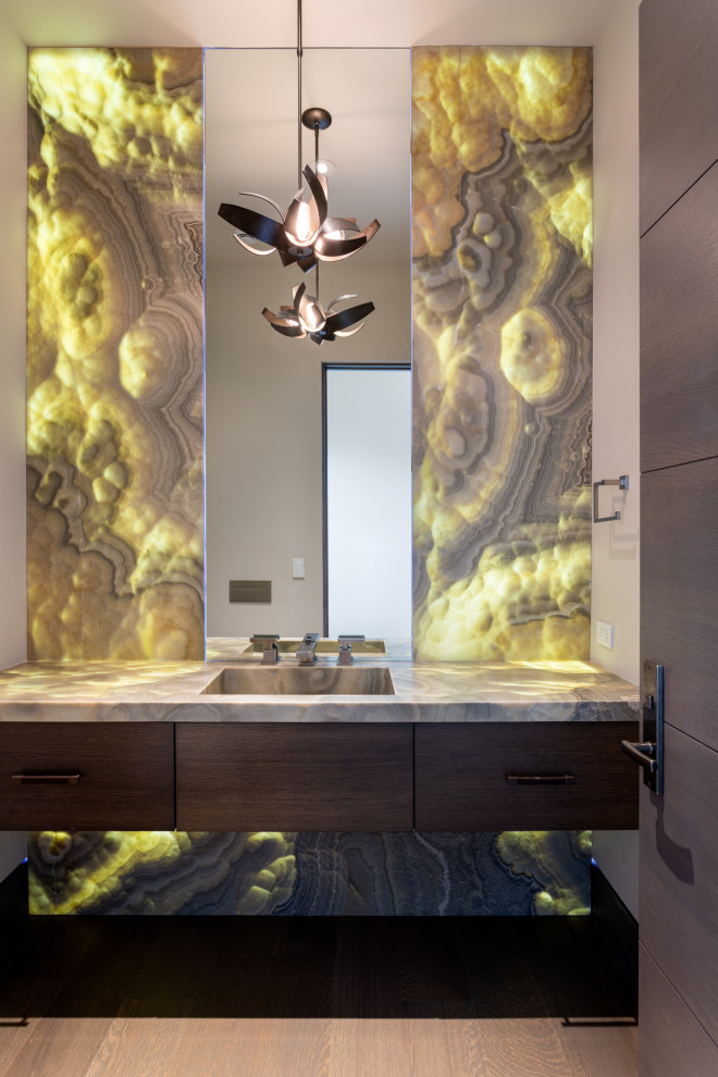Inspiration for a medium sized world-inspired cloakroom in Salt Lake City with black cabinets, green tiles, brown walls, medium hardwood flooring, an integrated sink, onyx worktops, brown floors, multi-coloured worktops, a floating vanity unit and wallpapered walls.