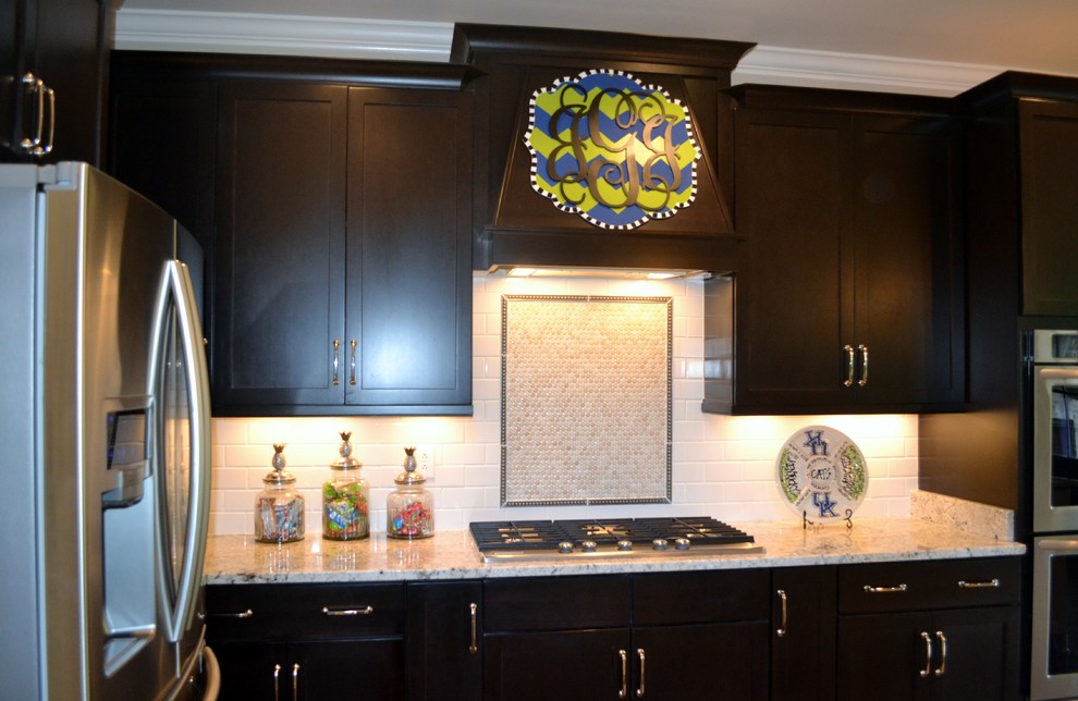 Inspiration for a mid-sized transitional eat-in kitchen remodel with raised-panel cabinets, dark wood cabinets, granite countertops, stainless steel appliances and an island