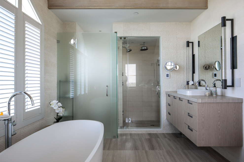 Inspiration for a mid-sized beach style master wet room bathroom in New York with flat-panel cabinets, medium wood cabinets, a freestanding tub, beige walls, medium hardwood floors, a vessel sink, wood benchtops, a hinged shower door, a single vanity and a floating vanity.