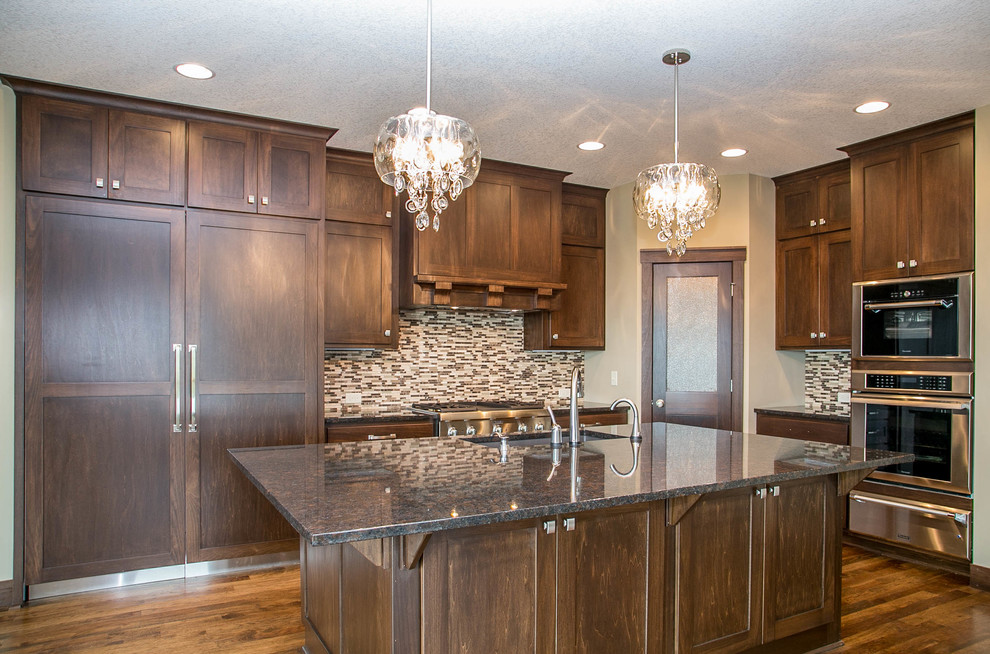 Example of a transitional l-shaped dark wood floor open concept kitchen design in Minneapolis with a drop-in sink, shaker cabinets, dark wood cabinets, granite countertops, multicolored backsplash, ceramic backsplash, stainless steel appliances and an island