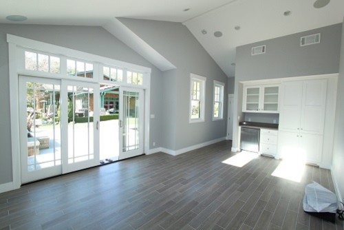 Inspiration for a transitional open concept family room in San Francisco with a game room, grey walls and grey floor.