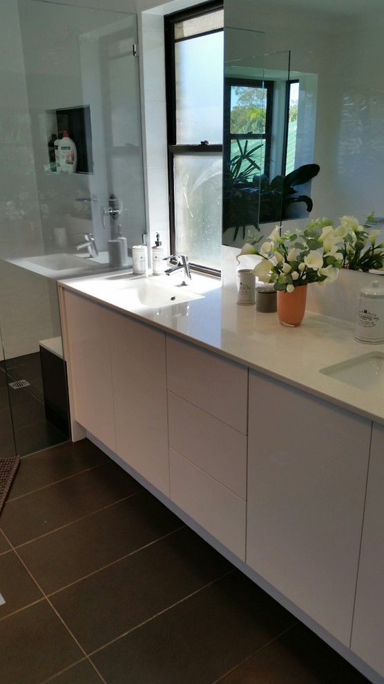 Mid-sized contemporary master bathroom in Brisbane with flat-panel cabinets, a hot tub, a corner shower, white tile, porcelain tile, ceramic floors, an integrated sink, black floor and an open shower.