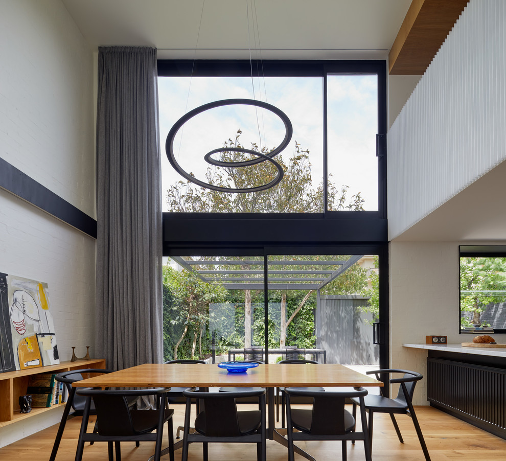 Design ideas for an expansive contemporary open plan dining in Melbourne with white walls, medium hardwood floors and brown floor.
