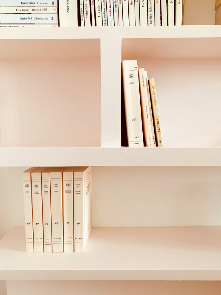 Bild på ett minimalistiskt allrum, med ett bibliotek