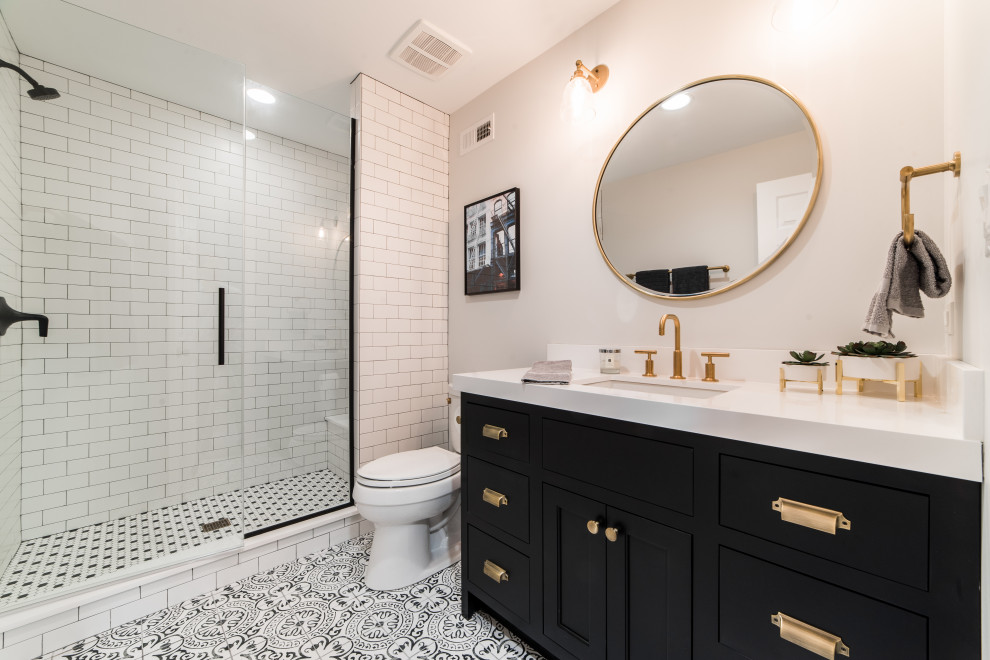Country bathroom in Chicago with black cabinets, a one-piece toilet, white tile, subway tile, an undermount sink, multi-coloured floor, a hinged shower door, white benchtops, a shower seat and a single vanity.