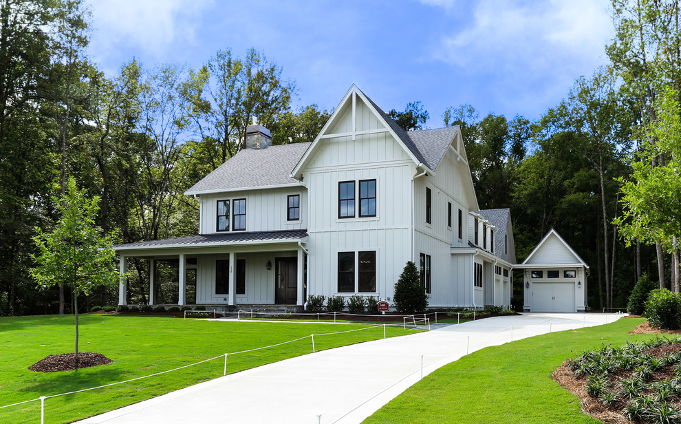 Large cottage white two-story wood and board and batten gable roof idea in Raleigh