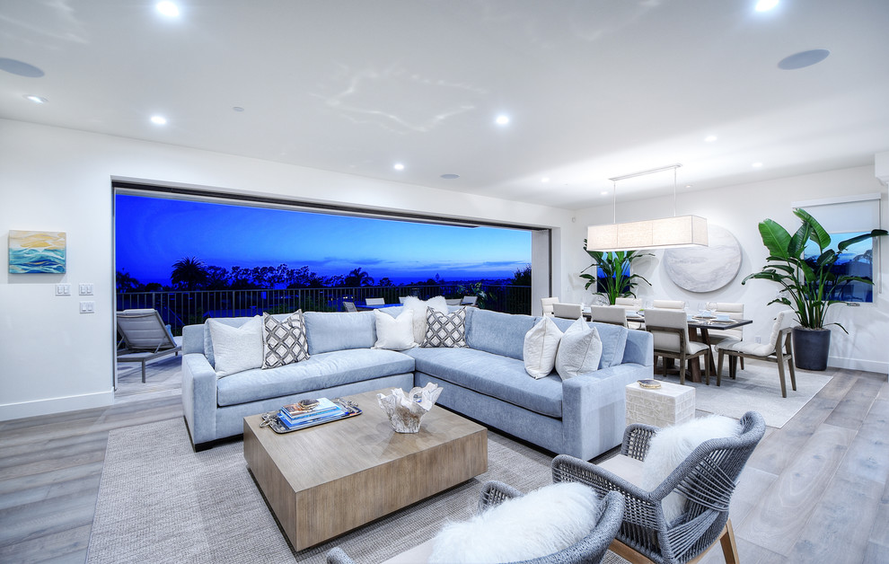 This is an example of a contemporary open concept living room in Los Angeles with a wall-mounted tv.