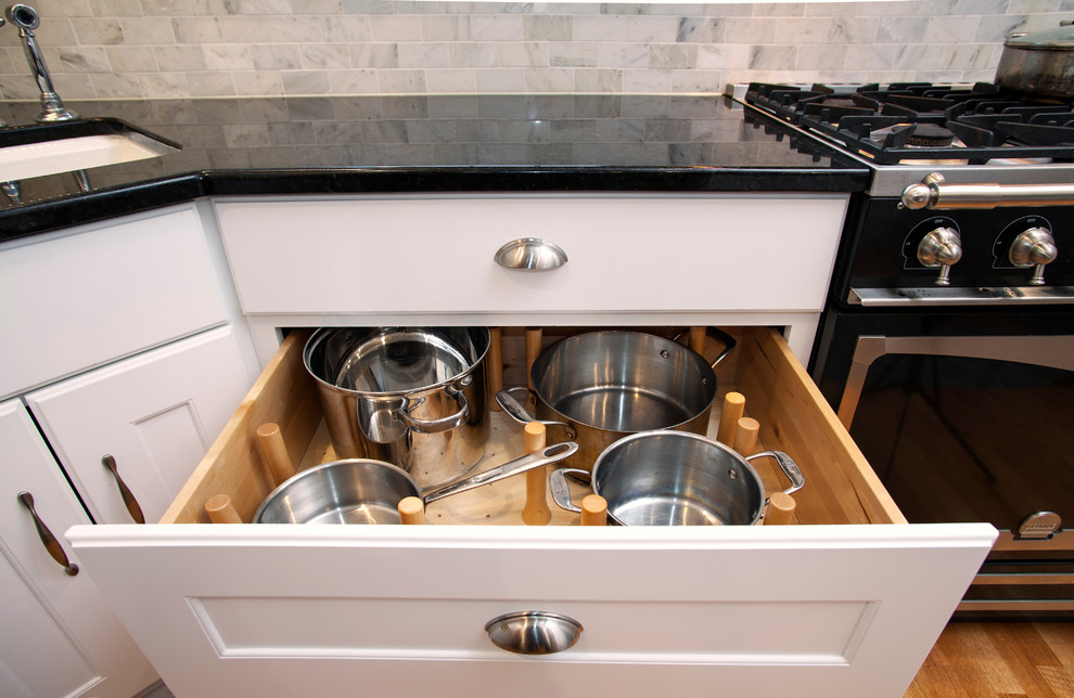 Kitchen - transitional kitchen idea with recessed-panel cabinets, white cabinets, granite countertops, gray backsplash, stone tile backsplash and black appliances
