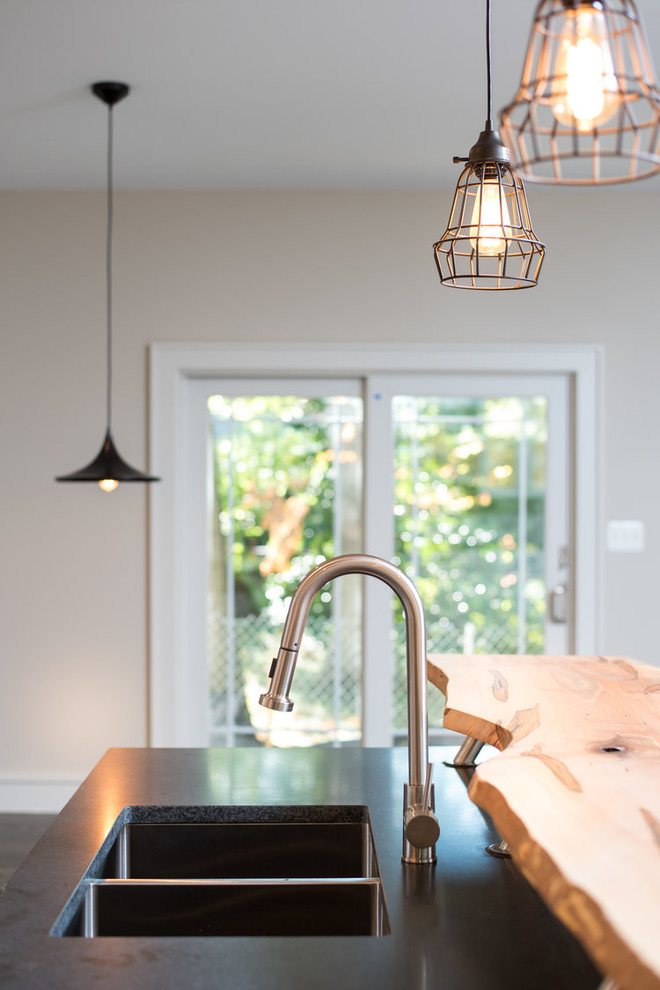 Transitional u-shaped eat-in kitchen photo in DC Metro with a double-bowl sink, shaker cabinets, white cabinets, granite countertops, brown backsplash, glass sheet backsplash, stainless steel appliances, an island and black countertops