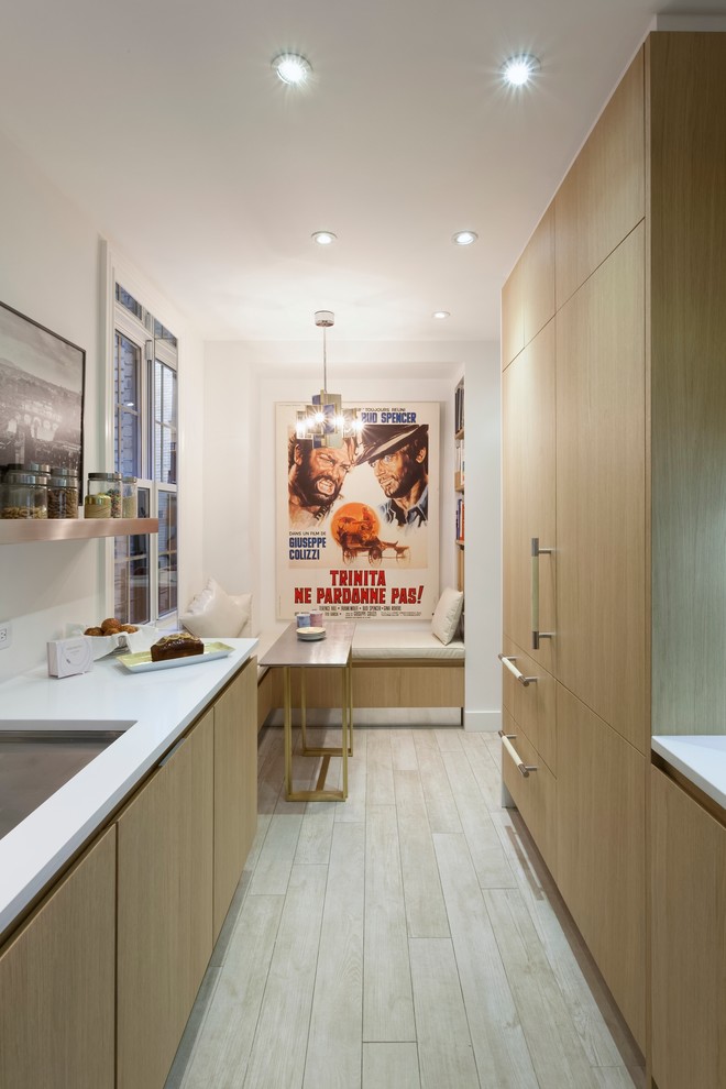 Contemporary galley kitchen in New York with no island, flat-panel cabinets, light wood cabinets, quartz benchtops, white splashback, glass sheet splashback, panelled appliances and an undermount sink.