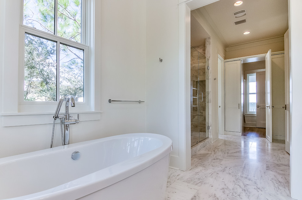 Photo of a large beach style master bathroom in Other with recessed-panel cabinets, white cabinets, a freestanding tub, a double shower, blue tile, subway tile, white walls, marble floors, an undermount sink, marble benchtops, white floor, a hinged shower door and white benchtops.
