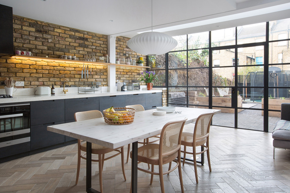 This is an example of a large contemporary open plan dining in London with medium hardwood floors and no fireplace.