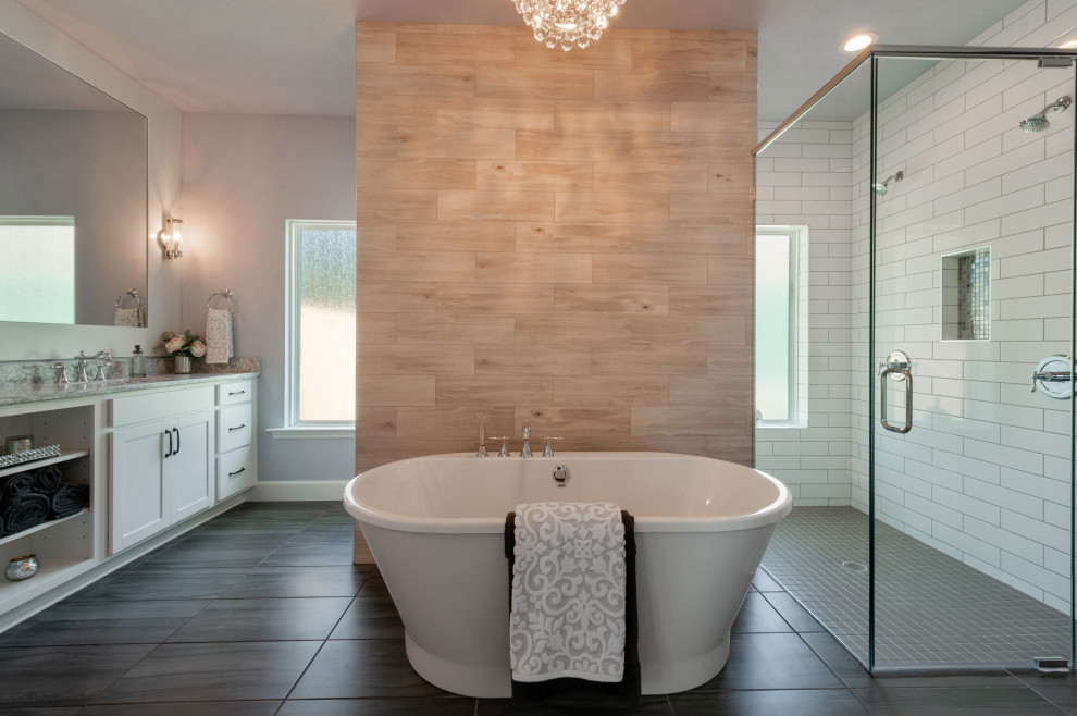 Country master bathroom in Other with white cabinets, a freestanding tub, a double shower, a one-piece toilet, wood-look tile, grey walls, a drop-in sink, grey floor, a hinged shower door, grey benchtops, a double vanity and a built-in vanity.