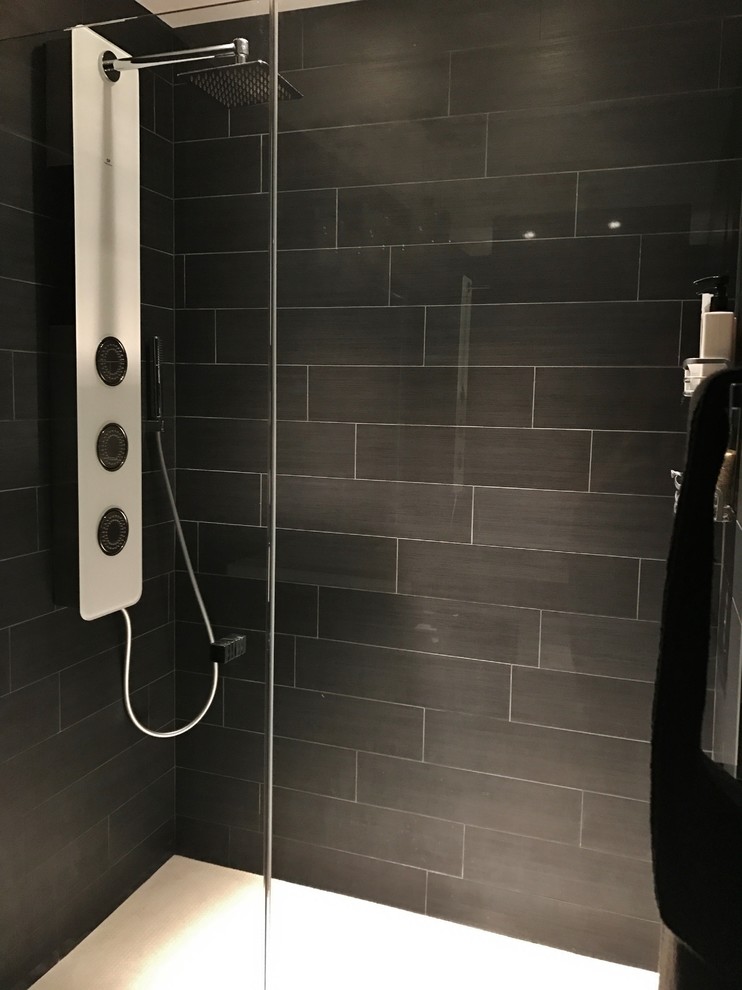 Kleines Modernes Duschbad mit flächenbündigen Schrankfronten, schwarzen Schränken, Toilette mit Aufsatzspülkasten, schwarz-weißen Fliesen, Zementfliesen, schwarzer Wandfarbe, Zementfliesen für Boden und integriertem Waschbecken in Chicago