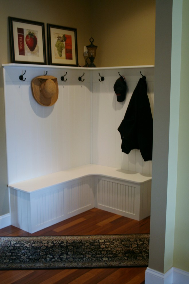 Large medium tone wood floor foyer photo with yellow walls