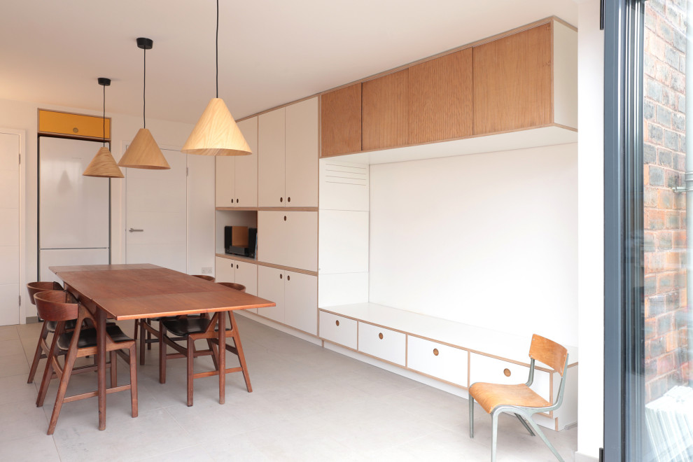 Inspiration for a large modern single-wall eat-in kitchen in London with white cabinets, laminate benchtops, yellow splashback, ceramic splashback, black appliances, no island, grey floor and grey benchtop.