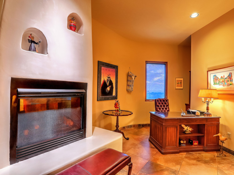 This is an example of a mid-sized master bedroom in Albuquerque with yellow walls, slate floors, a standard fireplace, a plaster fireplace surround and multi-coloured floor.