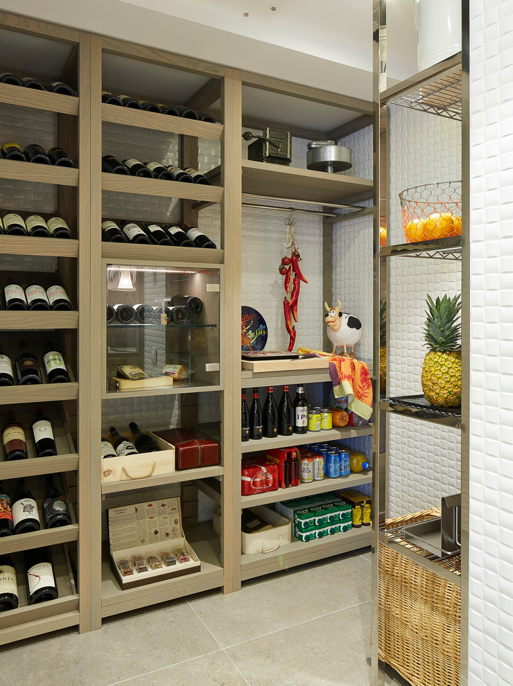 This is an example of a mid-sized contemporary wine cellar in Barcelona with ceramic floors and display racks.