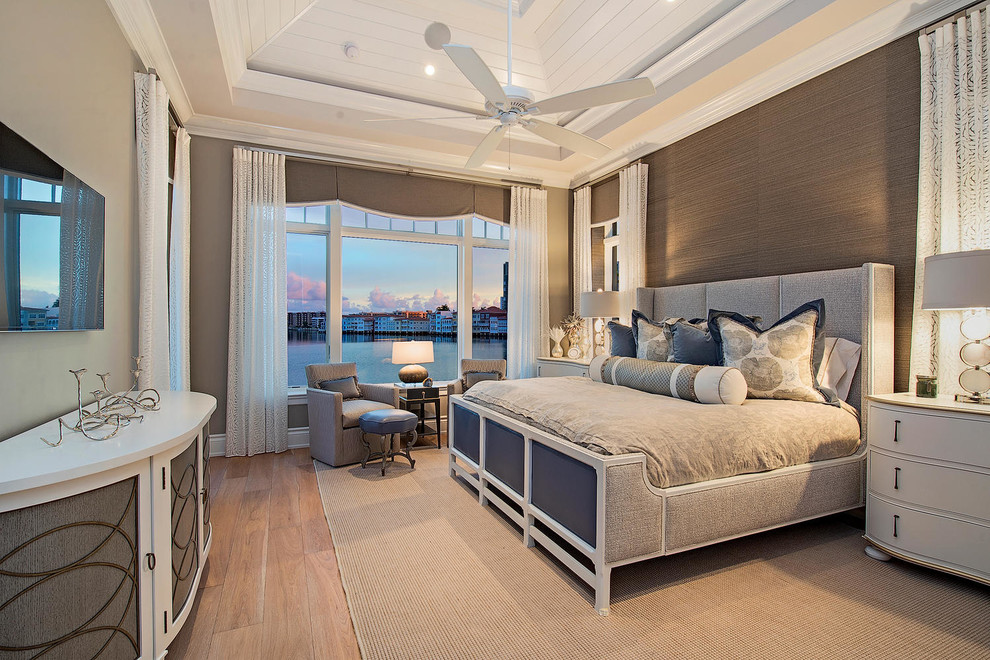 Design ideas for a large transitional master bedroom in Miami with beige walls, light hardwood floors, no fireplace and beige floor.