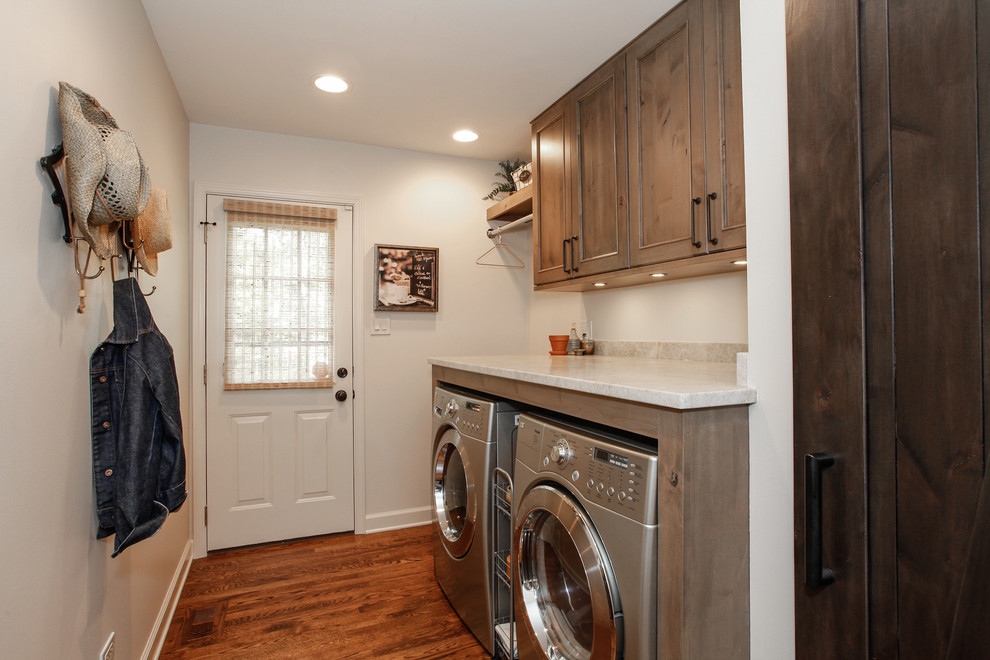 This is an example of a small country single-wall dedicated laundry room in Chicago with recessed-panel cabinets, medium wood cabinets, marble benchtops, white walls, medium hardwood floors and a side-by-side washer and dryer.