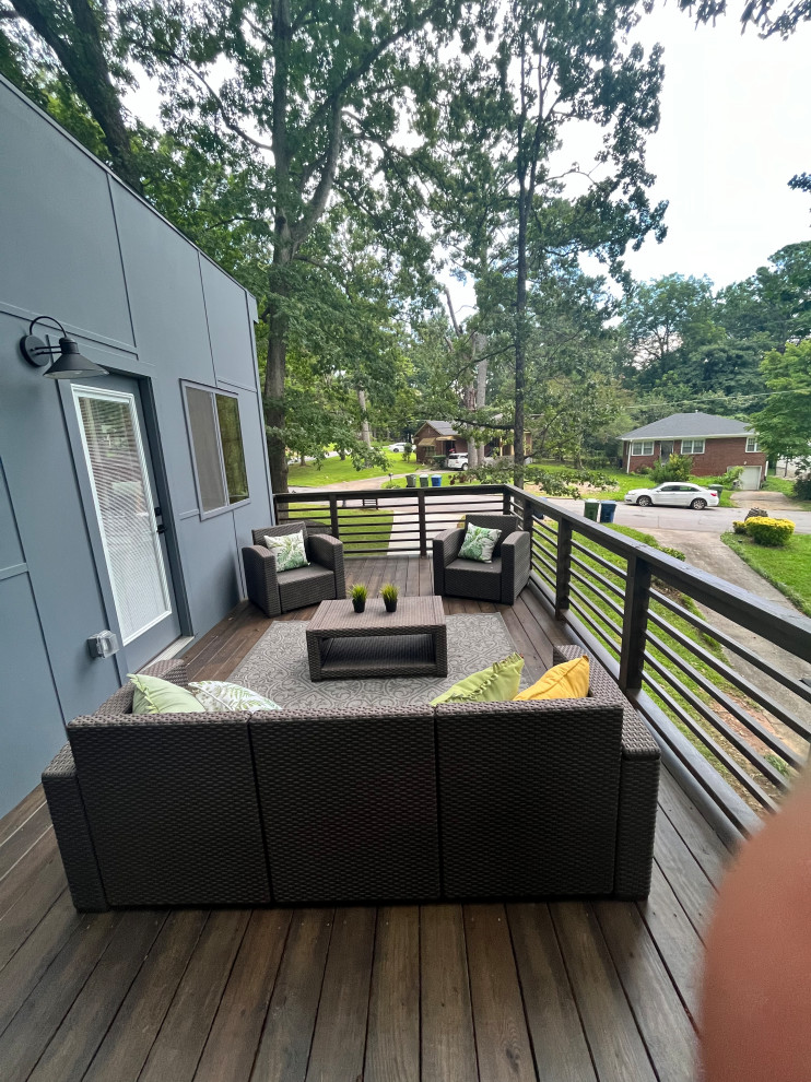 Example of a mid-sized trendy backyard second story privacy and wood railing deck design in Atlanta with a roof extension