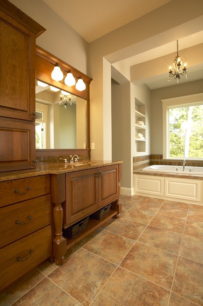 Inspiration for a large traditional master bathroom in Cedar Rapids with raised-panel cabinets, dark wood cabinets, a drop-in tub, beige walls, ceramic floors, an undermount sink, granite benchtops and beige floor.