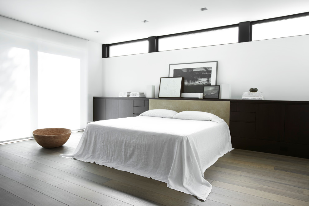 Photo of a contemporary bedroom in San Francisco with white walls, dark hardwood floors and no fireplace.