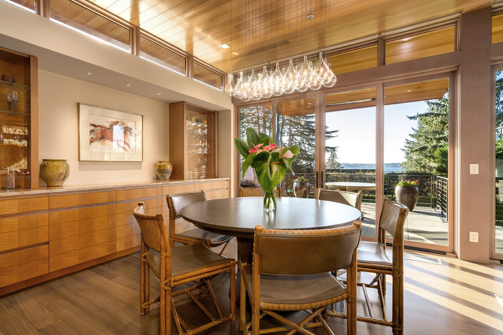 This is an example of a contemporary dining room in Seattle with beige walls, medium hardwood floors and brown floor.