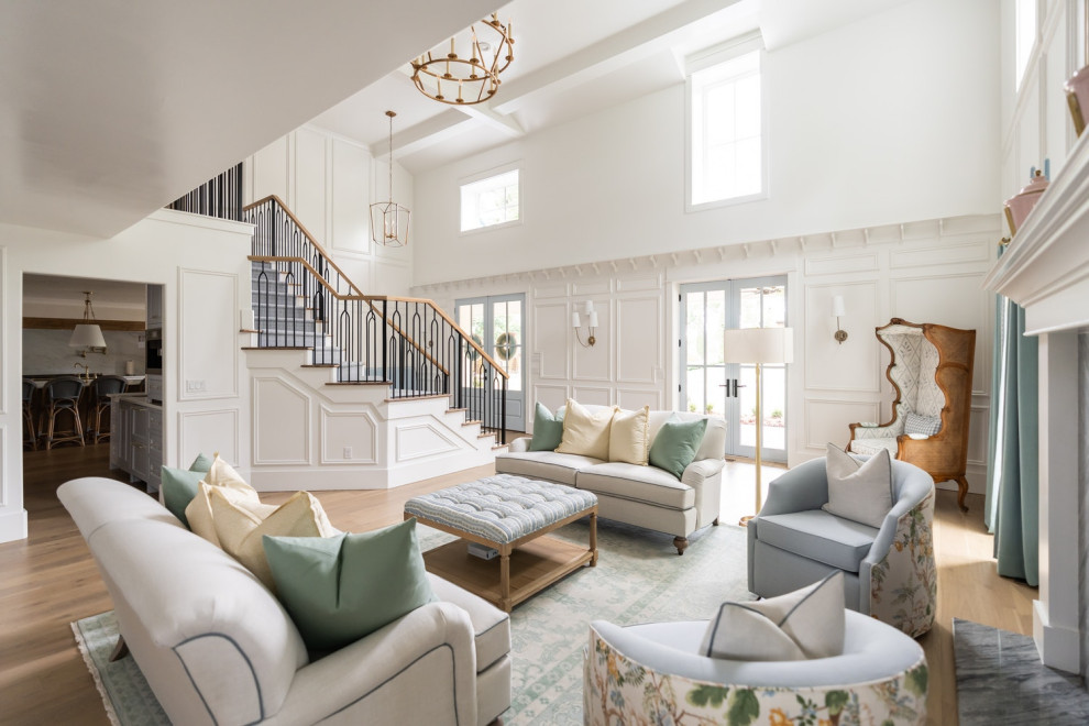 Photo of an expansive traditional formal loft-style living room in Oklahoma City with white walls, light hardwood floors, a standard fireplace, a stone fireplace surround, no tv, coffered and panelled walls.