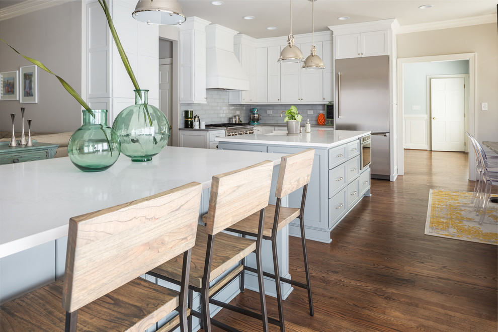 Huge transitional galley medium tone wood floor open concept kitchen photo in Raleigh with a farmhouse sink, flat-panel cabinets, white cabinets, quartz countertops, gray backsplash, ceramic backsplash, stainless steel appliances and two islands
