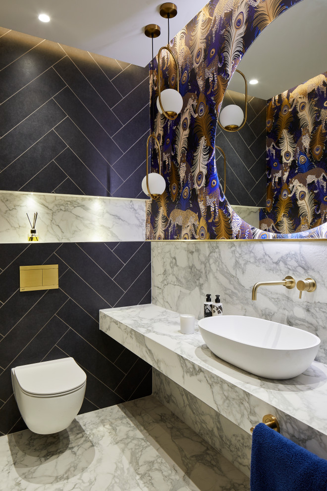 ロンドンにある小さなコンテンポラリースタイルのおしゃれなトイレ・洗面所 (壁掛け式トイレ、青いタイル、コンソール型シンク、大理石の洗面台、白い洗面カウンター) の写真