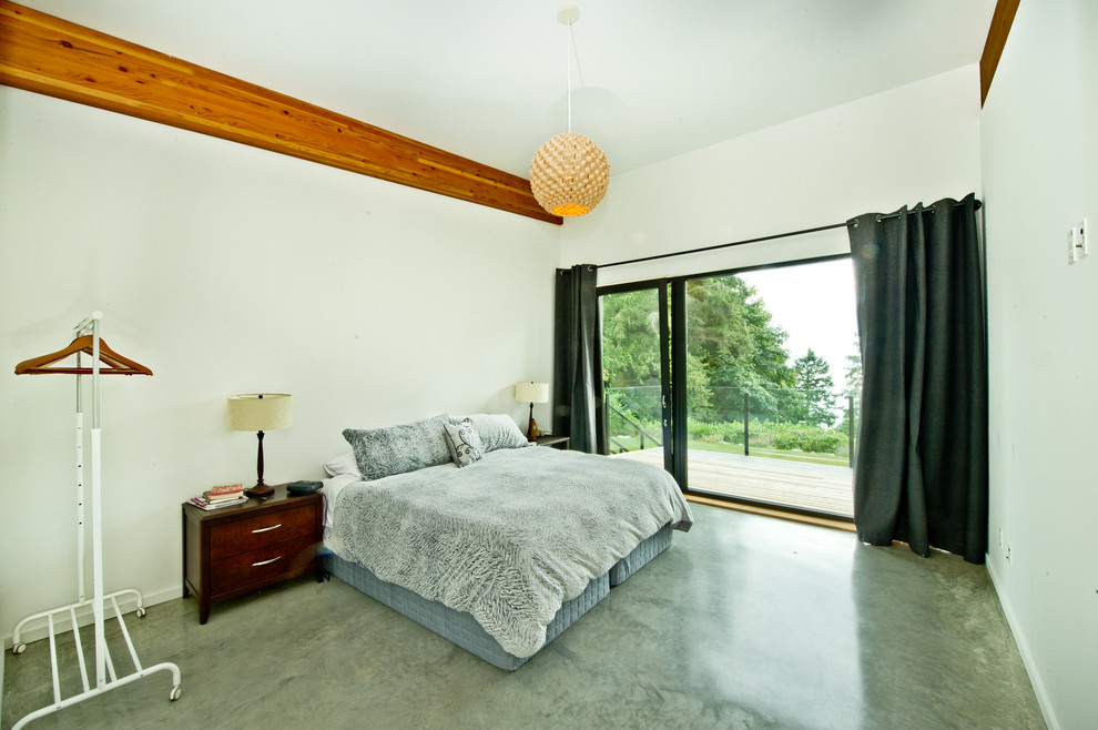 Inspiration for a large modern guest concrete floor bedroom remodel in Other with white walls