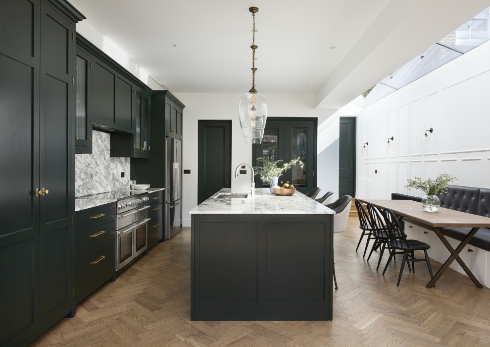 Inspiration for a large transitional eat-in kitchen in London with an undermount sink, shaker cabinets, green cabinets, marble benchtops, grey splashback, marble splashback, stainless steel appliances, medium hardwood floors, with island and grey benchtop.