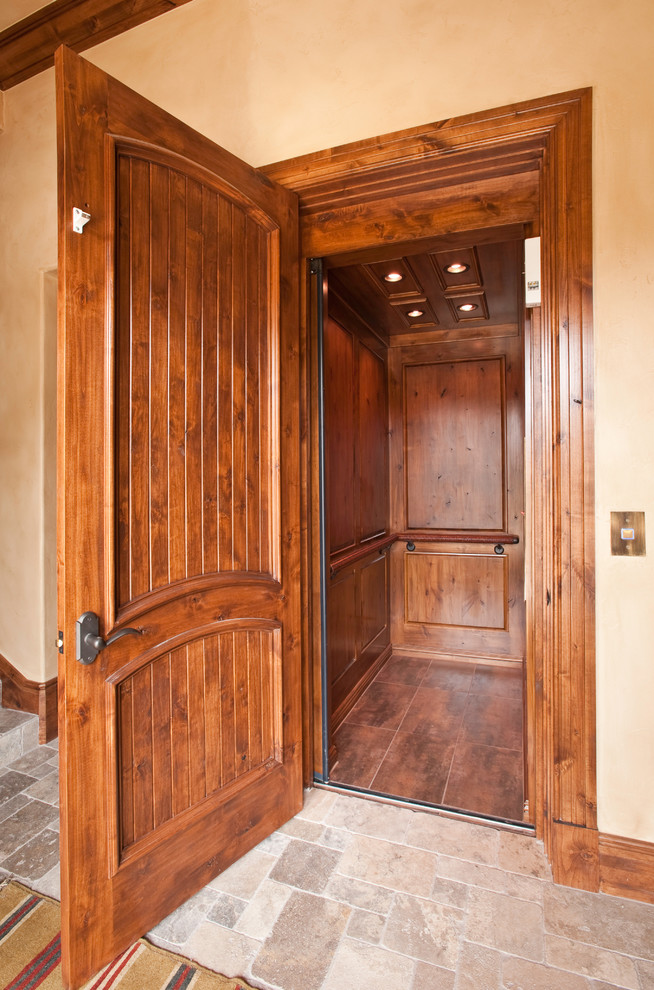 Small mountain style limestone floor hallway photo in Denver with beige walls