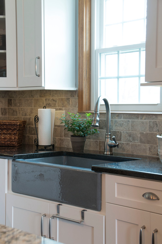 Eat-in kitchen - large transitional l-shaped medium tone wood floor eat-in kitchen idea with an undermount sink, shaker cabinets, white cabinets, granite countertops, gray backsplash, stone tile backsplash, stainless steel appliances and an island