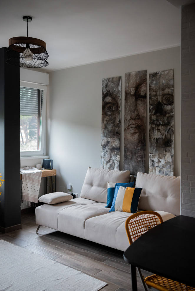Idee per un piccolo soggiorno industriale chiuso con pareti grigie, pavimento in gres porcellanato, pavimento marrone e con abbinamento di mobili antichi e moderni