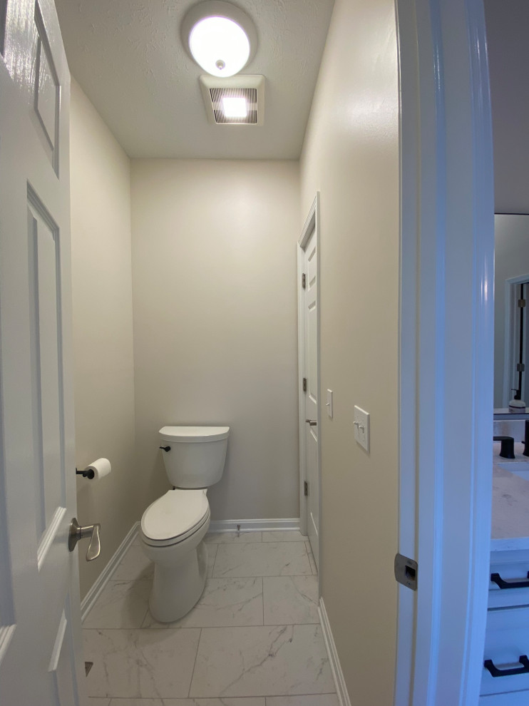 Aménagement d'un WC et toilettes moderne avec WC à poser et un mur blanc.