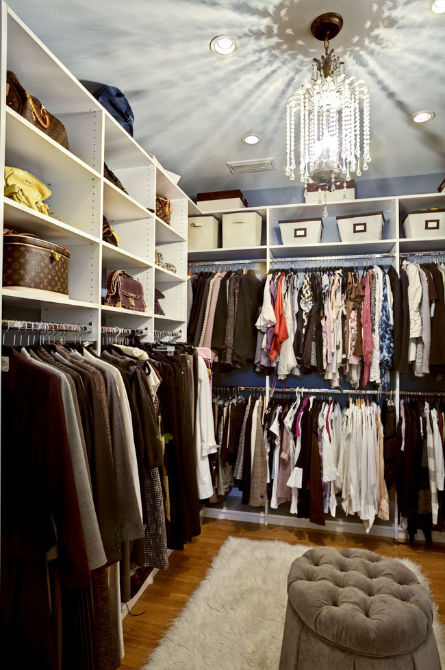 This is an example of a large traditional gender-neutral walk-in wardrobe in Tampa with open cabinets, white cabinets and medium hardwood floors.