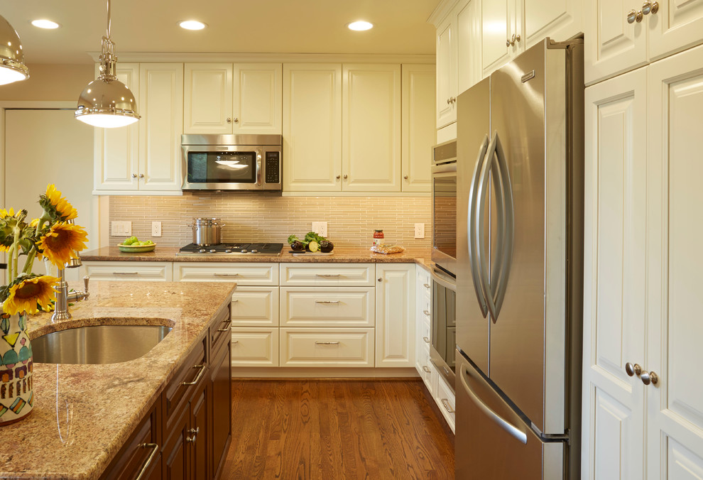 Mid-sized transitional l-shaped dark wood floor eat-in kitchen photo in Baltimore with an island, an undermount sink, raised-panel cabinets, white cabinets, granite countertops, beige backsplash, glass tile backsplash and stainless steel appliances