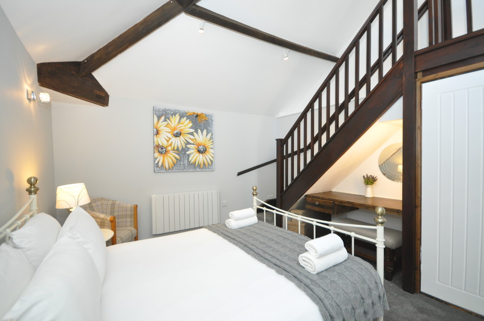 This is an example of a mid-sized traditional master bedroom in Devon with white walls, carpet and no fireplace.