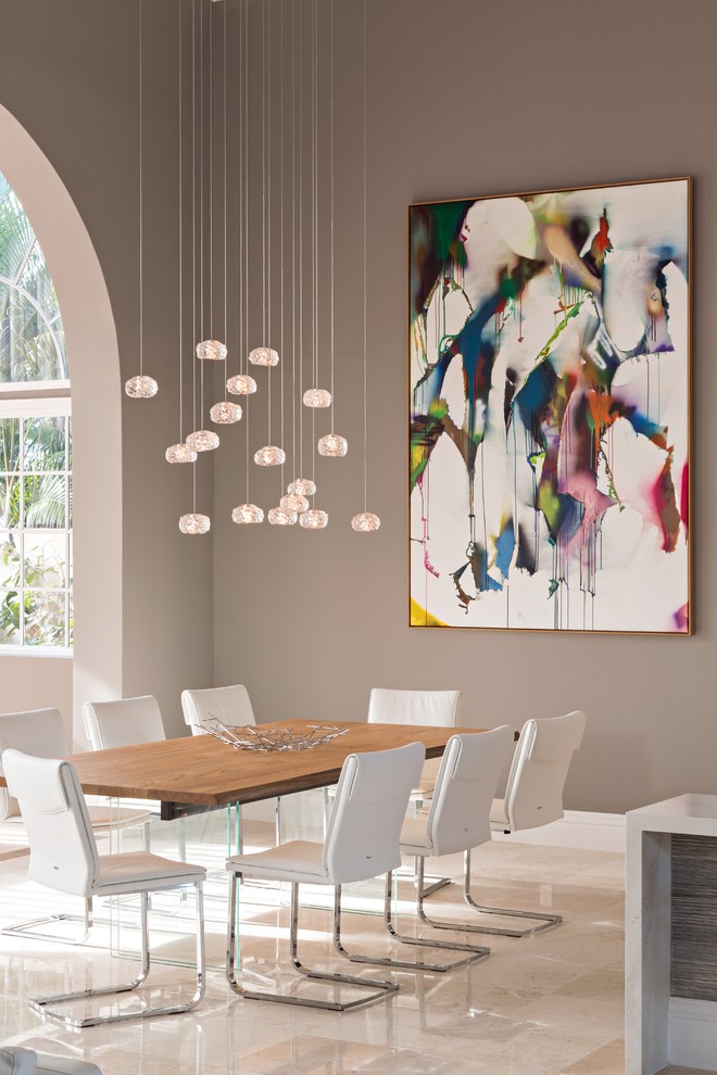 This is an example of a modern dining room in Miami with grey walls and marble floors.