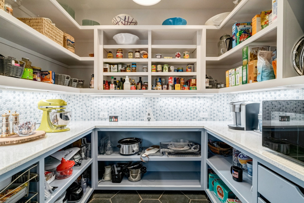This is an example of a modern kitchen pantry in Atlanta with blue cabinets, quartz benchtops, blue splashback, ceramic splashback, ceramic floors, black floor and white benchtop.