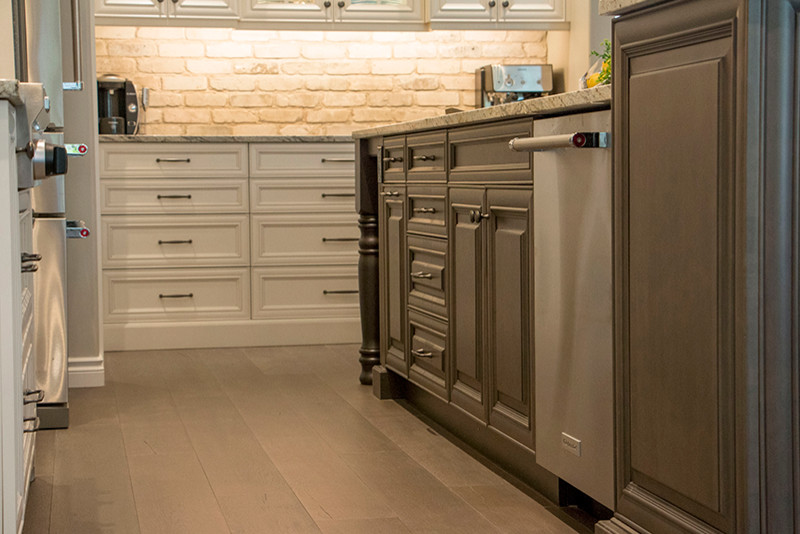 Example of a large transitional l-shaped home design design with a double-bowl sink, shaker cabinets, white cabinets, beige backsplash, stainless steel appliances and an island