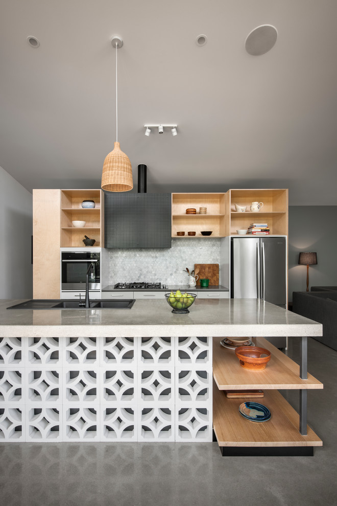 Photo of a contemporary galley open plan kitchen in Adelaide with a double-bowl sink, open cabinets, light wood cabinets, grey splashback, mosaic tile splashback, stainless steel appliances, concrete floors, with island and grey floor.