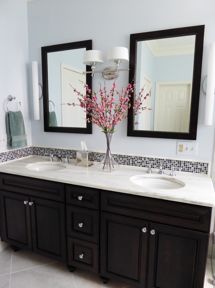 Double shower - mid-sized transitional master blue tile porcelain tile double shower idea in Indianapolis with an undermount sink, beaded inset cabinets, dark wood cabinets, marble countertops, blue walls and a two-piece toilet