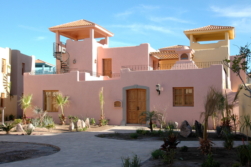 Photo of a two-storey pink house exterior with a hip roof.