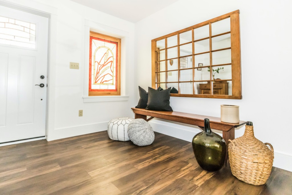 Inspiration for a mid-sized vinyl floor and brown floor foyer remodel with white walls and a white front door