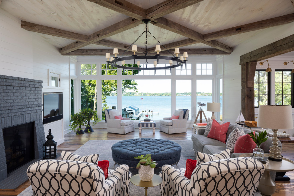 Inspiration for a large beach style open concept living room in Minneapolis with white walls, medium hardwood floors, a standard fireplace, a brick fireplace surround, a built-in media wall, brown floor, coffered and planked wall panelling.