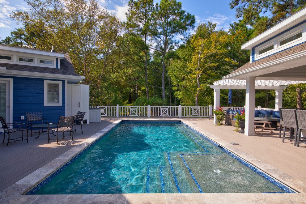 Example of a mid-sized classic backyard rectangular pool design in Other with decking