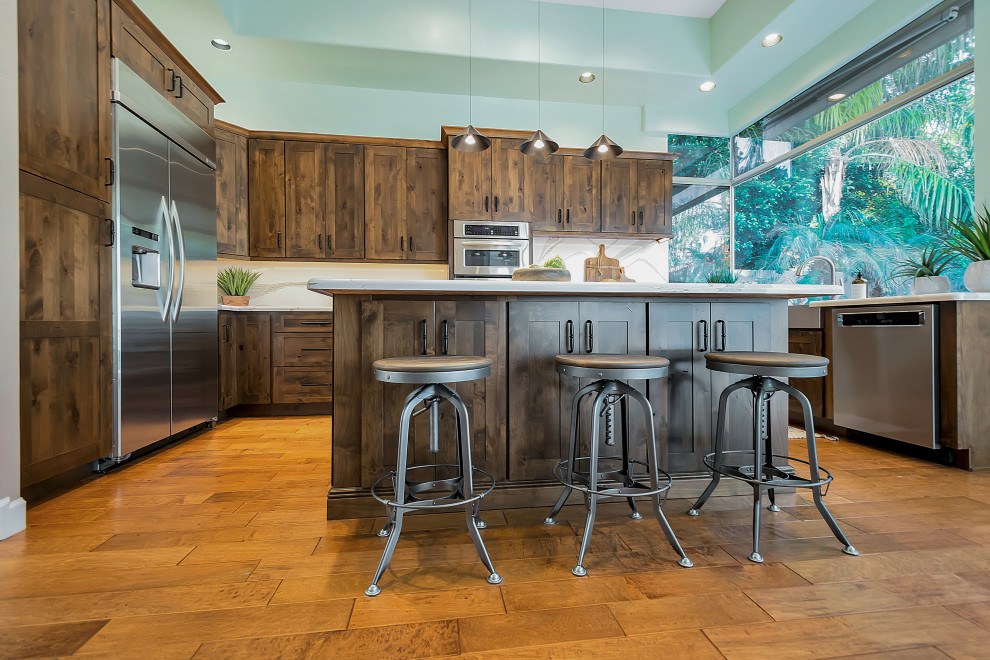 Large transitional u-shaped open concept kitchen photo in Phoenix with a farmhouse sink, shaker cabinets, dark wood cabinets, quartz countertops, white backsplash, quartz backsplash, stainless steel appliances, an island and white countertops